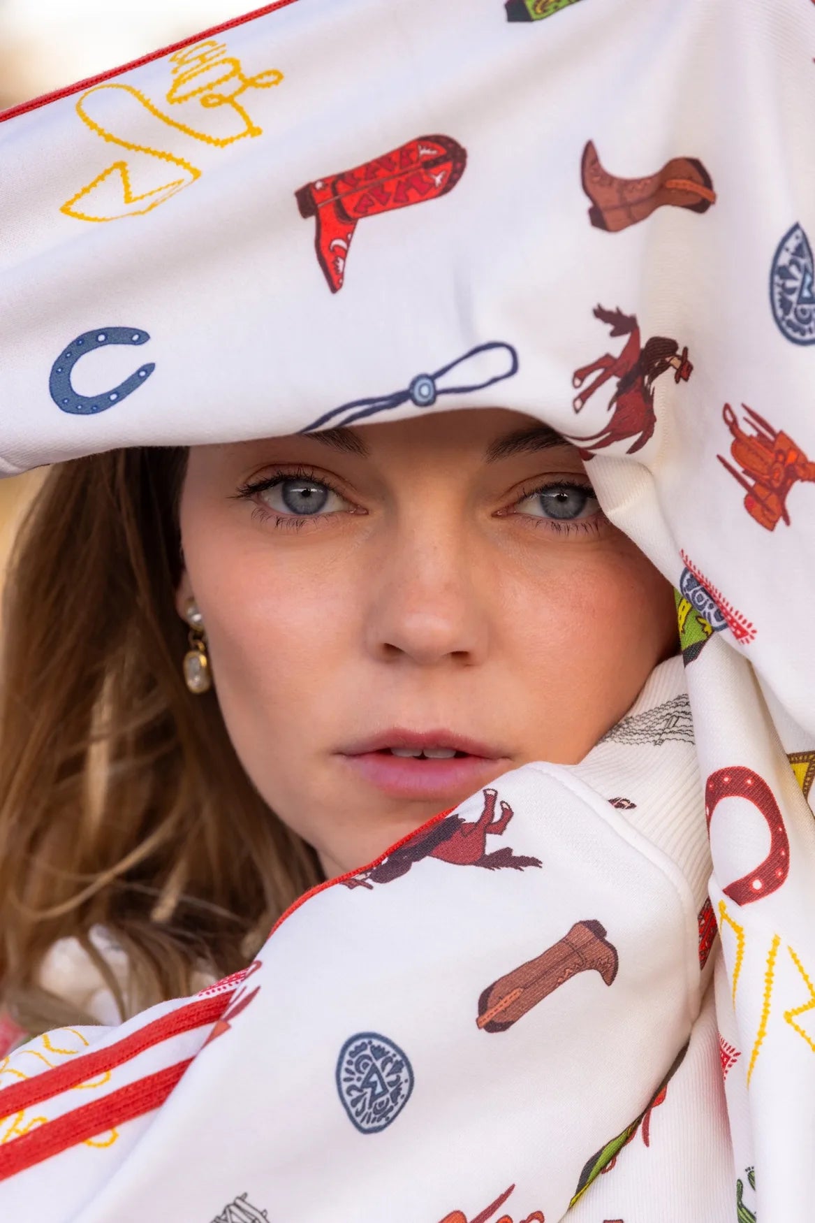 Peeking out from under the HOWDY & HAPPY zip up hood